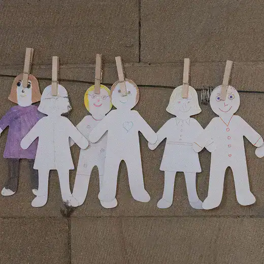 Paper chain of children holding hands, representing community support.